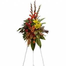 Tall floral standing spray with red, orange, and yellow blooms