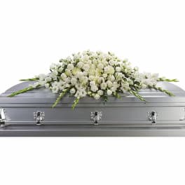 White floral casket spray on a silver casket