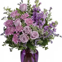 Lavender roses and purple flowers arranged in a vase