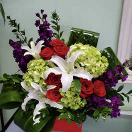 Bouquet of red roses, white lilies, and green hydrangeas with purple flowers