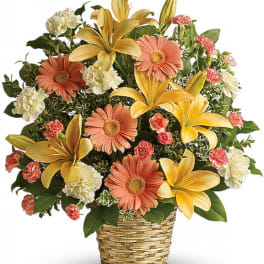 Mixed bouquet of lilies, gerbera daisies, and carnations in a woven basket