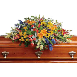 Colorful flower spray arranged on a wooden casket