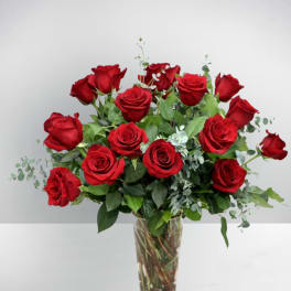 Red roses arranged in a clear glass vase