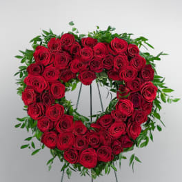 Heart-shaped wreath of red roses on a standing easel