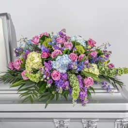 Large floral casket spray with pink roses and purple blooms