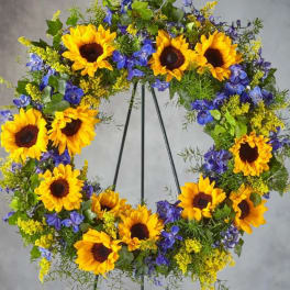 Sunflower wreath with blue flowers on a metal stand