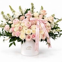 Large pastel bouquet of roses and ranunculus in a white hat box with pink ribbon
