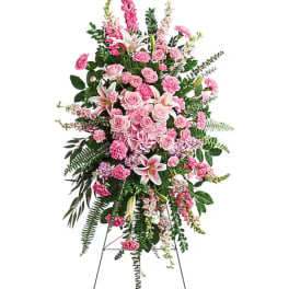 Tall pink floral standing spray with roses, lilies, and carnations on an easel