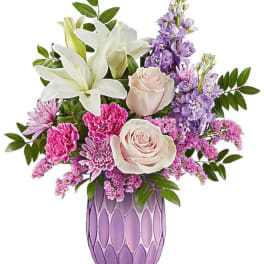 Pink and white floral arrangement in a purple vase