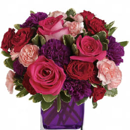 Bouquet of pink, red, and purple flowers in a purple vase
