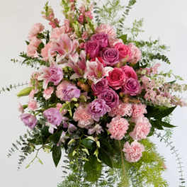 Large pink and lavender floral arrangement with cascading greenery