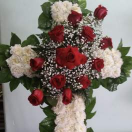 Cross-shaped floral arrangement with red roses and white flowers