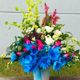 Bright mixed bouquet in a blue vase with blue, pink, white, and green flowers