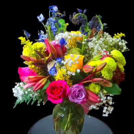 Colorful mixed bouquet in a glass vase on a stool