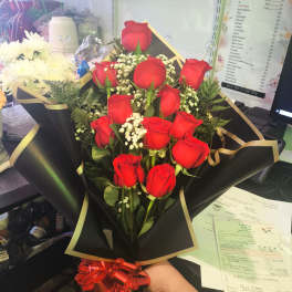 Bouquet of red roses with baby's breath in black wrap and red ribbon