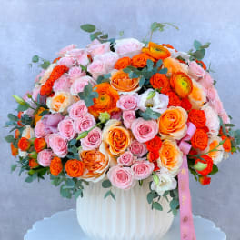 Large bouquet of pink and orange roses in a white vase