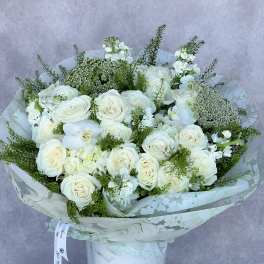 White rose bouquet with orchids in a white vase