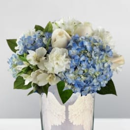 Blue hydrangeas and white roses in a glass vase