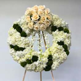 White floral wreath with cream roses on a stand
