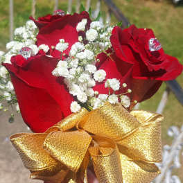 Small bouquet of red roses with white baby's breath and a gold ribbon