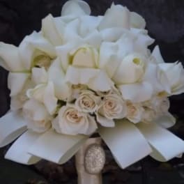 White bouquet with roses and calla lilies tied with a satin ribbon