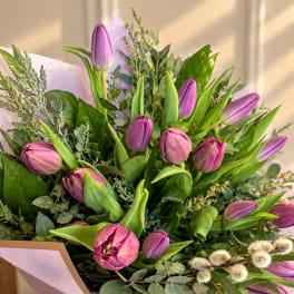 Bouquet of purple tulips with greenery and pale pink wrapping
