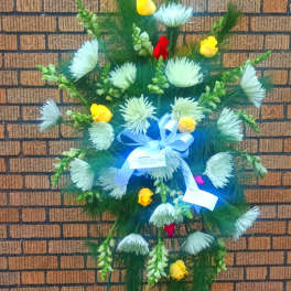 Standing floral spray with white blooms, yellow roses, and blue ribbon