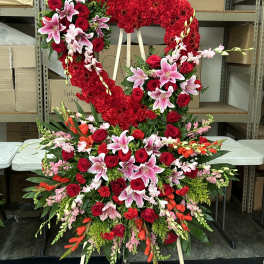 Large heart-shaped floral standing spray with red roses and pink lilies