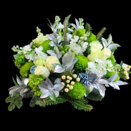 Green and white floral arrangement with silver foliage and berries