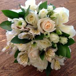 Bouquet of white roses and white alstroemeria with green leaves
