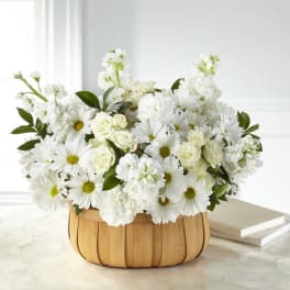 White daisies and roses arranged in a woven basket