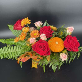 Bouquet of red roses, orange mums, and small pink roses with fern foliage