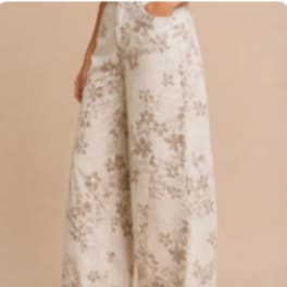 Person wearing cream floral wide-leg pants against a beige background