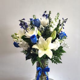 Blue and white bouquet with lilies and roses in a glass vase