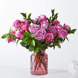 Pink roses arranged in a pink glass vase