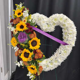 Heart-shaped floral tribute with sunflowers and white chrysanthemums