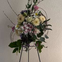 Tall floral arrangement with pink and white blooms on a stand