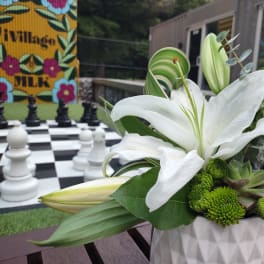 White lilies and green mums in a white vase
