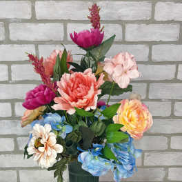 Colorful mixed flower arrangement in a tall green vase