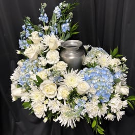 White and blue floral arrangement around a silver urn