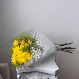 Bouquet of yellow flowers wrapped in clear plastic