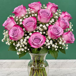 Pink roses and white baby's breath in a clear glass vase