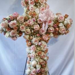 Cross-shaped floral arrangement of pink and peach roses