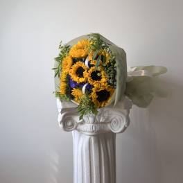 Bouquet of yellow sunflowers wrapped in pale paper