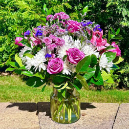 Pink roses and white daisies in a clear glass vase