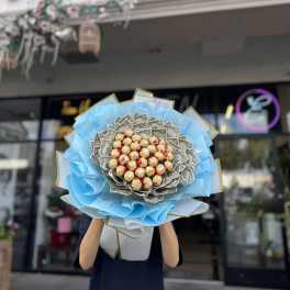 Bouquet of dollar bills and chocolate candies wrapped in blue paper