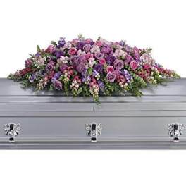 Lavender and pink floral casket spray on a silver casket