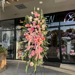 Tall pink floral standing arrangement on a metal easel