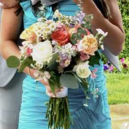 Woman holding a pastel bouquet with roses and small mixed flowers