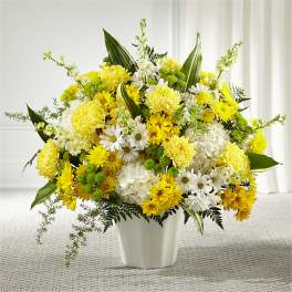 Yellow and white mixed flower arrangement in a white vase